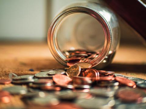 Money jar with coins spilling out